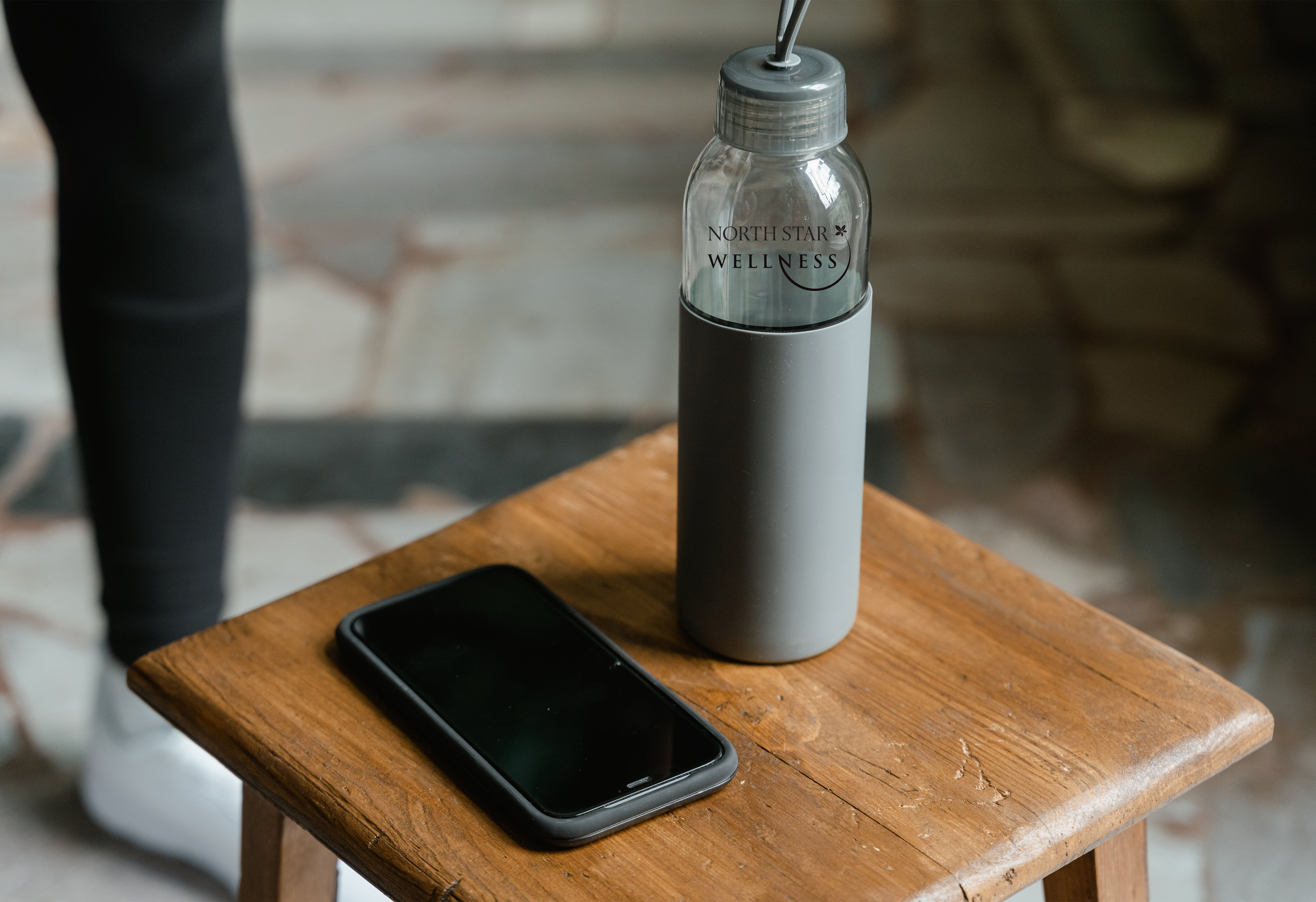 Custom printed water bottle next to phone on table